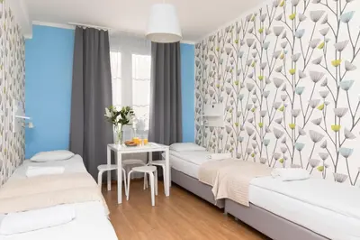 a bedroom with two beds and a table at Freedom Hostel in Kraków