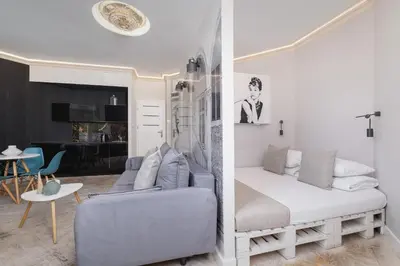 a bedroom with a bed and a living room at Marylin Studio - Czysta 5 Street in Kraków