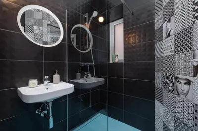 a black tiled bathroom with two sinks and a mirror at Marylin Studio - Czysta 5 Street in Kraków
