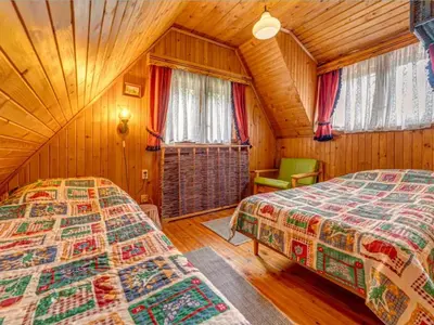 a bedroom with two beds in a wooden cabin at Klimatyczny domek w górach in Sordelówka