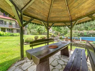 a wooden picnic table under a wooden roof at Klimatyczny domek w górach in Sordelówka