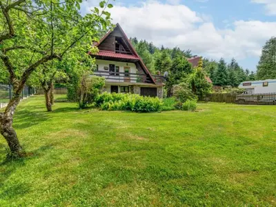 a house with a green yard with a tree at Klimatyczny domek w górach in Sordelówka
