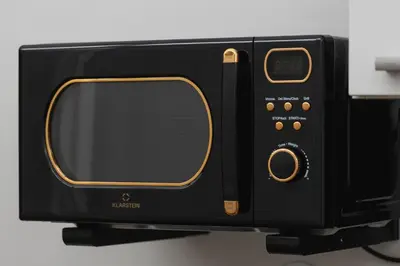 a black microwave oven sitting on top of a counter at 2 bedroom apartment - Sereno Fenn'a 5 street in Kraków