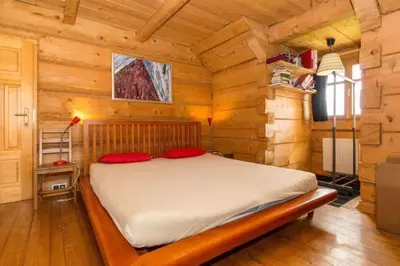 a bedroom with a bed in a wooden cabin at Holzvilla Nähe Krakau in Krzywaczka