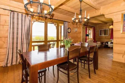 a dining room with a wooden table and chairs at Holzvilla Nähe Krakau in Krzywaczka