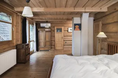 a bedroom with a white bed and a wooden ceiling at Holzvilla Nähe Krakau in Krzywaczka