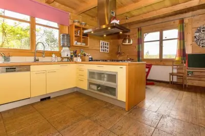 a kitchen with yellow cabinets and a stove at Holzvilla Nähe Krakau in Krzywaczka