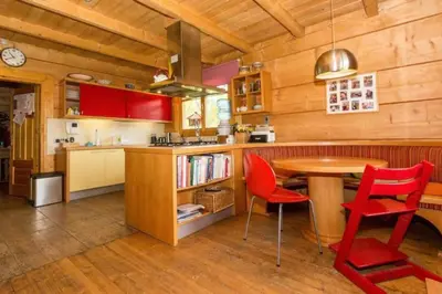 a kitchen with red chairs and a wooden table at Holzvilla Nähe Krakau in Krzywaczka