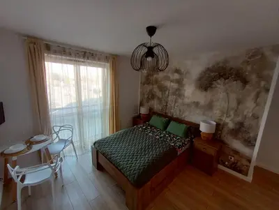 a bedroom with a bed and a table and a chandelier at Old Town Premium Apartment in Kraków