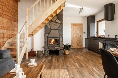 a living room with a fireplace and a staircase at Mokosz in PyzÃ³wka