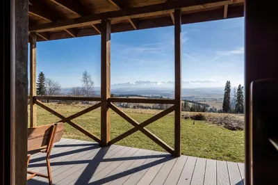 a view from the porch of a cabin with a bench at Mokosz in PyzÃ³wka