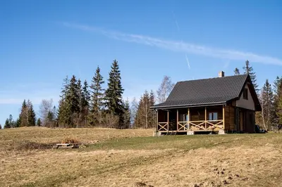 a log cabin on a hill in a field at Mokosz in PyzÃ³wka