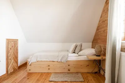 a bedroom with a bed with a wooden headboard at Mokosz in PyzÃ³wka
