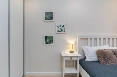a bedroom with a bed and a table with a lamp at Nad Sudołem Stylish Apartment by BookingHost in Kraków