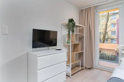 a living room with a tv on a dresser at Nad Sudołem Stylish Apartment by BookingHost in Kraków