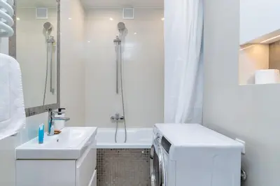 a white bathroom with a shower and a sink at Nad Sudołem Stylish Apartment by BookingHost in Kraków