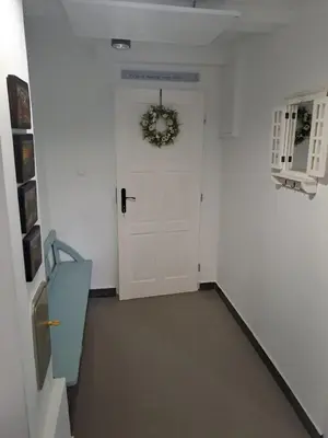 a hallway with a white door with a wreath on it at Górska Otulina in Wilkowisko