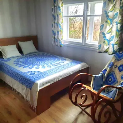 a bedroom with a bed and a chair and a window at Górska Otulina in Wilkowisko