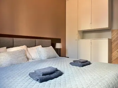 a bedroom with a bed with two towels on it at Comfy Apartment with home cinema projector, Cracow's heart in Kraków