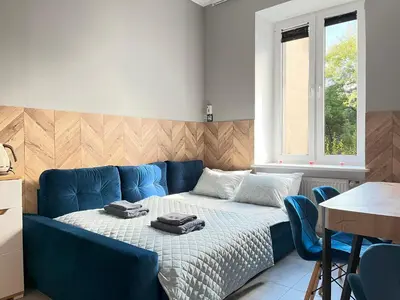 a bedroom with a blue bed with two bags on it at Comfy Apartment with home cinema projector, Cracow's heart in Kraków