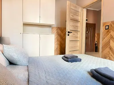 a bedroom with a bed with towels on it at Comfy Apartment with home cinema projector, Cracow's heart in Kraków