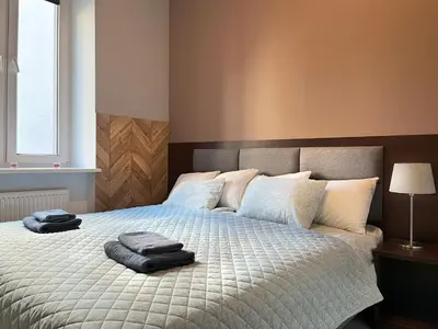 a bedroom with a bed with two towels on it at Comfy Apartment with home cinema projector, Cracow's heart in Kraków