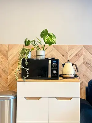 a microwave sitting on top of a counter with plants at Comfy Apartment with home cinema projector, Cracow's heart in Kraków
