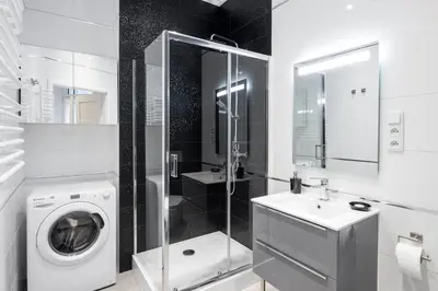 a bathroom with a washing machine and a sink at Apartment with Air Conditioning in the heart of Cracow heart in Kraków