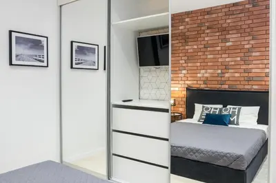a bedroom with a bed and a brick wall at Apartment with Air Conditioning in the heart of Cracow heart in Kraków