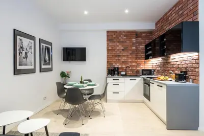 a kitchen with white cabinets and a table and chairs at Apartment with Air Conditioning in the heart of Cracow heart in Kraków