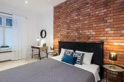 a bedroom with a brick wall and a bed at Apartment with Air Conditioning in the heart of Cracow heart in Kraków