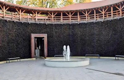 a fountain in front of a building with a wall at Salt Mine Apartment Bochnia by OTH in Bochnia