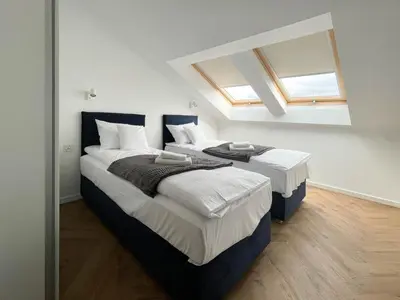 two beds in a room with two windows at S45 APT by PROMODERO in Kraków