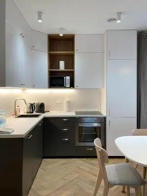 a kitchen with black and white appliances and a table at S45 APT by PROMODERO in Kraków