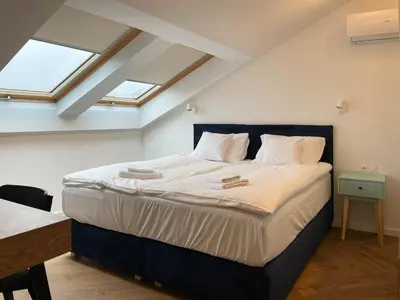 a large bed in a room with skylights at S45 APT by PROMODERO in Kraków