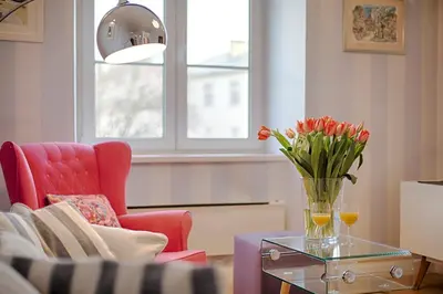 a vase of yellow flowers on a glass table in a living room at Tyzenhauz Apartments Kazimierz in Kraków