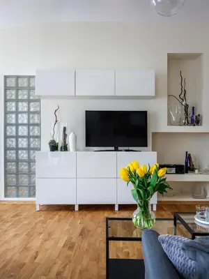 a kitchen with white cabinets and a blue couch at Tyzenhauz Apartments Kazimierz in Kraków