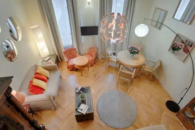 a dining room and living room with a table and chairs at Tyzenhauz Apartments Kazimierz in Kraków