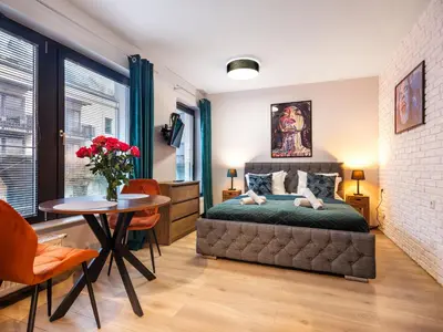a living room with a couch and a brick wall at Tyzenhauz Apartments Kazimierz in Kraków
