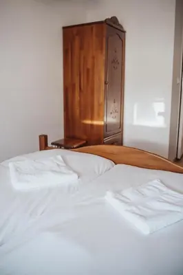 a bedroom with two white beds and a wooden cabinet at Zajazd Hetmański-Noclegi-Nowy Wiśnicz in Nowy Wiśnicz