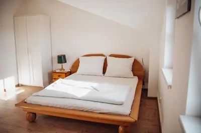 a bedroom with a bed with white sheets and pillows at Zajazd Hetmański-Noclegi-Nowy Wiśnicz in Nowy Wiśnicz