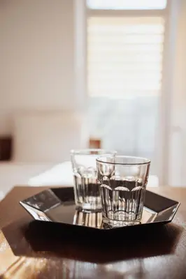 two glasses sitting on a tray on a table at Zajazd Hetmański-Noclegi-Nowy Wiśnicz in Nowy Wiśnicz