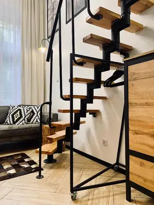 a black spiral staircase in a living room with a couch at Apartment Premium Jacuzzi for couples, Old Town in Kraków