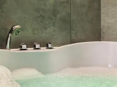 a bath tub with a faucet in a bathroom at Apartment Premium Jacuzzi for couples, Old Town in Kraków