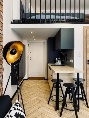 a kitchen with a table and stools in a room at Apartment Premium Jacuzzi for couples, Old Town in Kraków