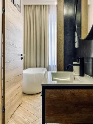 a bathroom with a tub and a sink and a mirror at Apartment Premium Jacuzzi for couples, Old Town in Kraków