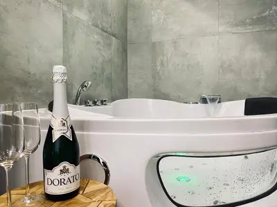 a bottle of champagne sitting next to a bath tub at Apartment Premium Jacuzzi for couples, Old Town in Kraków
