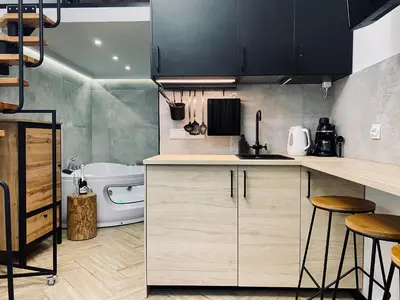 a kitchen with wooden cabinets and a bath tub at Apartment Premium Jacuzzi for couples, Old Town in Kraków