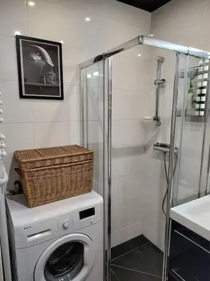 a washing machine with a basket on top of it in a bathroom at Star Wars Climate Apartment in Kraków