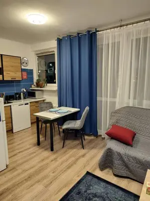 a living room with a table and a kitchen at Star Wars Climate Apartment in Kraków